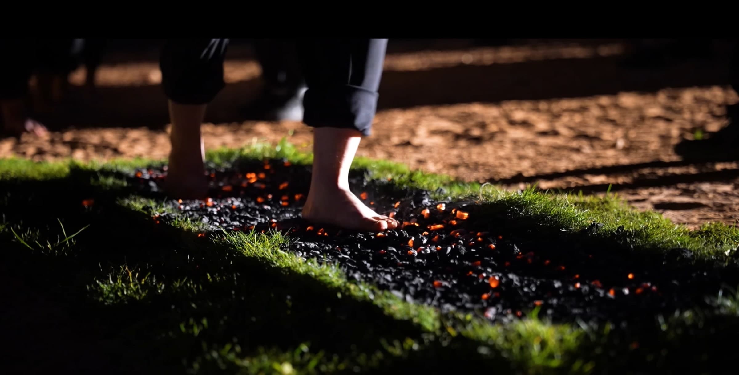 A participant walking barefoot across glowing coals during a CORE leadership experience